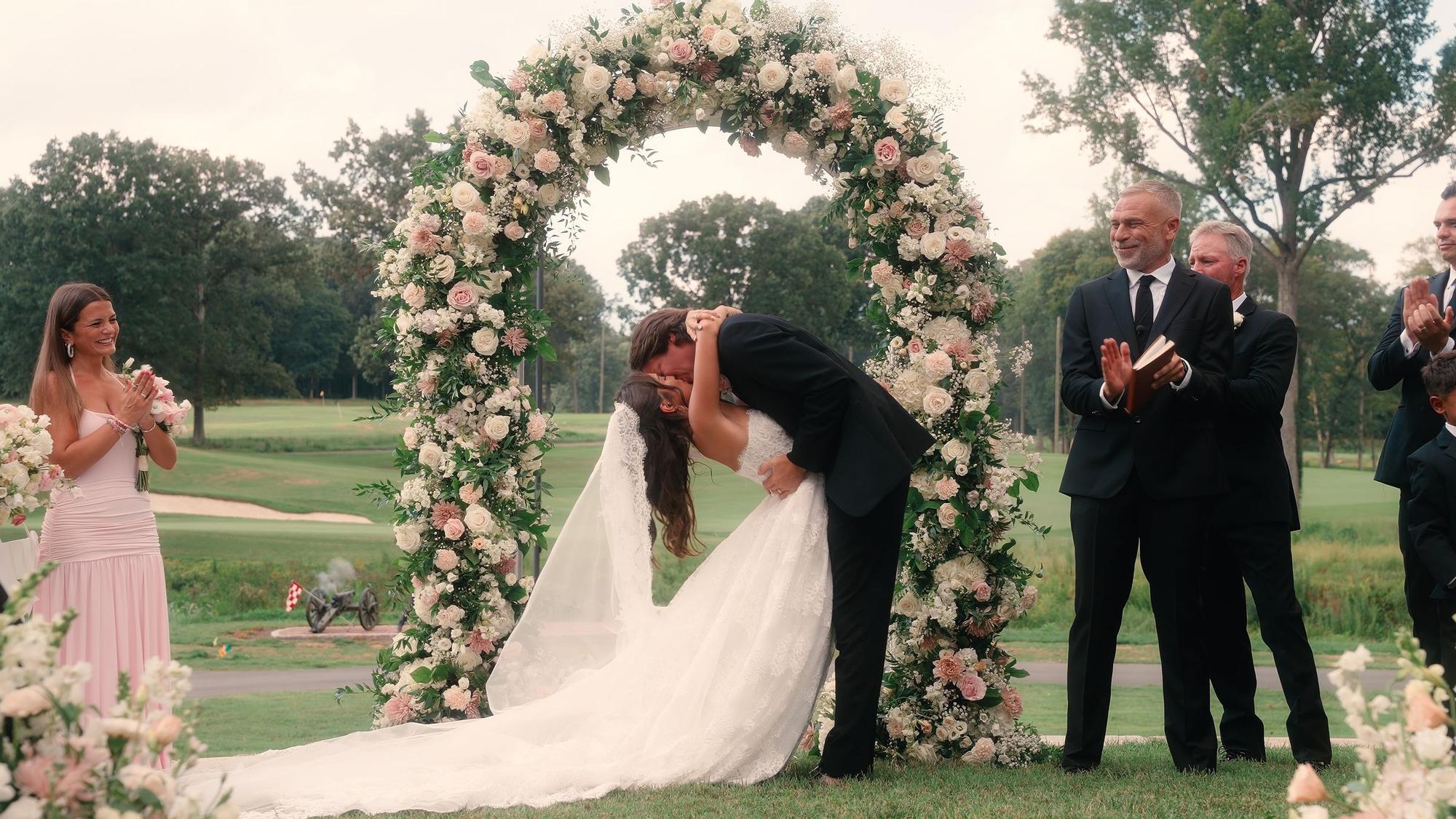 Couple kissing under a floral arch